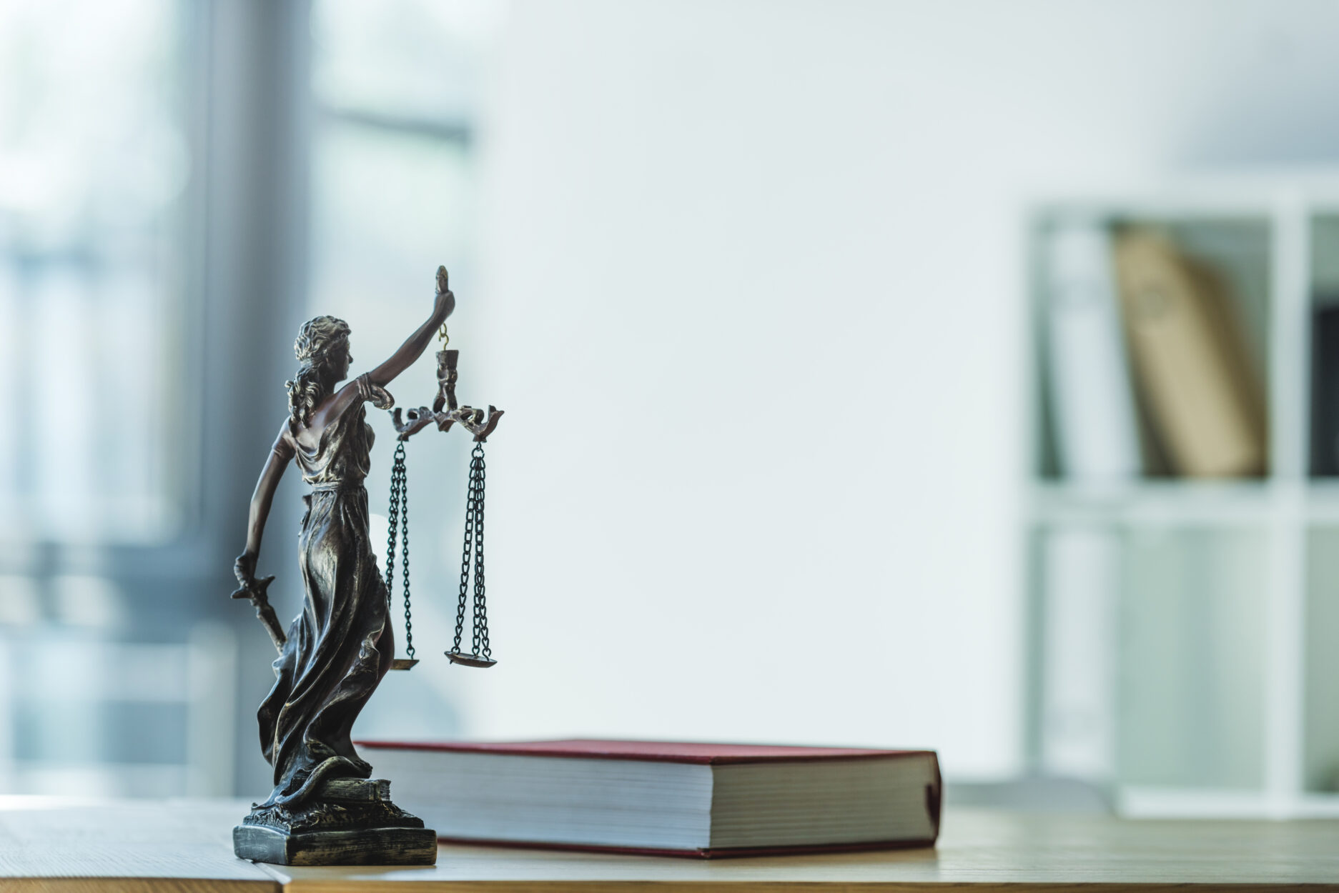 Book with lady justice holding balance.